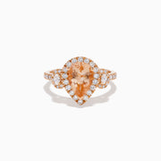 The 14K Rose Gold Pear Morganite and Diamond Halo Ring showcases a peach-hued pear morganite with sparkling diamond halo and accents, all set in 14K rose gold, against a white background.