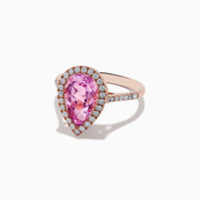 The 14K Rose Gold Kunzite and Diamond Ring features a pear-shaped pink kunzite center stone, surrounded by a halo of small white diamonds, set in a rose gold band and photographed on a plain white background.