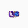 The 14k Rose Gold Amethyst and Tanzanite Toi Et Moi Ring features a rectangular purple amethyst and a cushion-cut blue tanzanite side by side on a minimalist band, displayed against a white background.