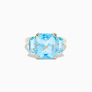 The Ocean Bleu 14K Yellow Gold Sky Blue Topaz 3-Stone Ring showcases a large rectangular blue topaz center stone with two smaller rectangular stones on each side, set against a white background.