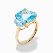 The Ocean Bleu 14K Yellow Gold Sky Blue Topaz 3-Stone Ring showcases a large rectangular blue topaz center stone with two smaller rectangular stones on each side, set against a white background.