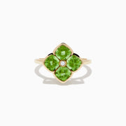 The 14K Yellow Gold Peridot and Diamond Ring displays a clover-shaped design with four faceted green peridots and a central round diamond, shown against a white background.