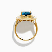 The 14K Yellow Gold London Blue Topaz and Diamond Double Halo Ring features an oval London Blue Topaz at the center, encircled by two halos of sparkling round and baguette-cut diamonds.