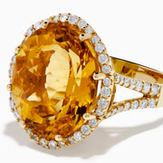 The Sunset 14K Yellow Gold Citrine and Diamond Halo Ring features a large oval citrine surrounded by sparkling diamonds, beautifully set against a plain white background.
