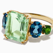 The 14K Yellow Gold Amethyst, Blue Topaz, and Chrome Diopside Cocktail Ring features a large rectangular amethyst center stone, flanked by two oval blue topaz and two smaller chrome diopside stones on each side.