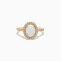 The Aurora 14K Yellow Gold Opal and Diamond Ring showcases an oval opal center, haloed by round diamonds and accented with more diamonds along its elegant band.