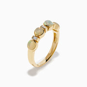 The 14K Yellow Gold Opal and Diamond Bezel Band showcases four round opals and three small rectangular diamonds set in a row, displayed on a white background.