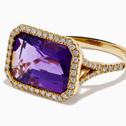 The 14K Yellow Gold Amethyst and Diamond Halo East West Cocktail Ring showcases a rectangular purple amethyst center with a diamond halo, set on yellow gold, displayed on a plain white background.