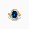 The Ocean Blue 14K Gold London Blue Topaz and Diamond Ring showcases a large oval topaz centerpiece, accented by two wavy rows of sparkling diamonds.