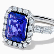 The Effy Hematian 18K White Gold Tanzanite and Diamond Halo Ring showcases a large rectangular blue tanzanite at the center, encircled by a diamond halo with additional diamonds set along the band.