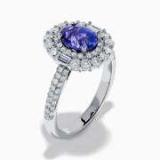 The 18K White Gold Purple Sapphire and Diamond Double Halo Ring features an oval purple sapphire center, two rows of white diamonds encircling it, and additional diamonds set along the band.