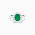 The Effy Hematian 18K White Gold Oval Emerald and Diamond Halo Ring features a vibrant oval emerald at the center, surrounded by a sparkling diamond halo with additional diamonds set along the elegant band.