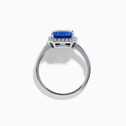 The Nahla Siri 14K Gold Tanzanite and Diamond Ring features a large emerald-cut tanzanite centerpiece, surrounded by a halo of sparkling diamonds, set in elegant gold and showcased against a white background.