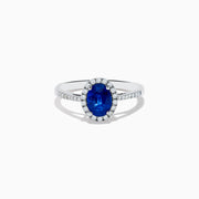 The 14K White Gold Oval Blue Sapphire and Diamond Ring features an oval blue sapphire center, a halo of sparkling diamonds, and additional diamonds set along the band.