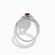 The Ruby Royale 14K White Gold Ruby and Diamond Ring features a central oval ruby with intersecting diamond-encrusted bands, beautifully set against a plain white background.
