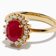 The 14K Yellow Gold Ruby and Diamond Halo Ring showcases an oval ruby center gemstone surrounded by a halo of round white diamonds, set in yellow gold and displayed against a white background.
