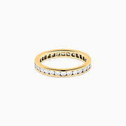 The 14K Yellow Gold Channel Set Diamond Eternity Band, 1.00 TCW, showcases a continuous row of round white diamonds in a channel setting, displayed on a white background.