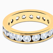 The 14K Yellow Gold Channel Set Diamond Eternity Band, 3.00 TCW, features round diamonds encircling the band and is displayed on a white background.