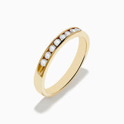 The 14K Yellow Gold 10-Stone Channel Set Diamond Band, 0.25 TCW, features a row of channel-set round diamonds along the band and is displayed on a white background.