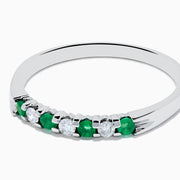 The 14K White Gold 7-Stone Emerald & Diamond Band, 0.25 TCW, showcases alternating round emeralds and diamonds set in a row along the band, displayed on a plain white background.