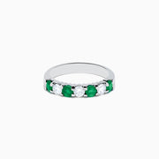 This 14K White Gold 7-Stone Emerald & Diamond Band, 1.00 TCW, features alternating round emeralds and sparkling white diamonds set in a sleek silver band.