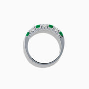 This 14K White Gold 7-Stone Emerald & Diamond Band, 1.00 TCW, features alternating round emeralds and sparkling white diamonds set in a sleek silver band.