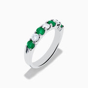 This 14K White Gold 7-Stone Emerald & Diamond Band, 1.00 TCW, features alternating round emeralds and sparkling white diamonds set in a sleek silver band.