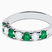 This 14K White Gold 7-Stone Emerald & Diamond Band, 1.00 TCW, features alternating round emeralds and sparkling white diamonds set in a sleek silver band.