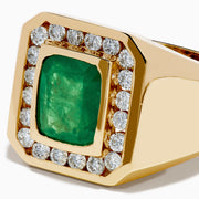The Men's 14K Yellow Gold Emerald and Diamond Statement Ring showcases a square green emerald center, bordered by small round white diamonds, displayed on a plain white background.