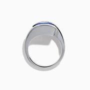 The Nahla 14K White Gold Floating Tanzanite and Diamond Ring showcases an oval blue tanzanite center with a curved band of round diamonds, all set in white gold and displayed on a white background.