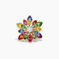 The Watercolors 14K Two-Tone Multi Sapphire Moving Petals Flower Ring features teardrop sapphires in yellow, orange, green, blue, and purple with sparkling white diamonds at the center—a vibrant floral piece for any jewelry collection.