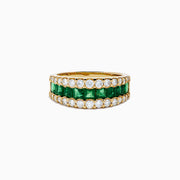 The Brasilica 14K Yellow Gold Emerald and Diamond Wide Band Ring features a symmetrical design with two rows of round diamonds framing horizontally set rectangular green emeralds, offering timeless sophistication.