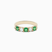 The Brasilica 14K Yellow Gold Emerald and Diamond Band Ring features alternating round emeralds and clear diamonds set in a row on the gold band.