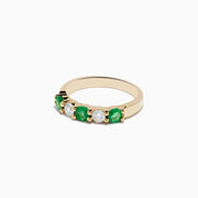 The Brasilica 14K Yellow Gold Emerald and Diamond Band Ring features alternating round emeralds and clear diamonds set in a row on the gold band.