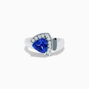 The Nahla Siri 14K White Gold Tanzanite and Diamond Ring showcases a large triangular blue tanzanite framed by a curved row of sparkling white diamonds, set against a white background.