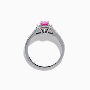 The 14K White Gold Pink Sapphire and Diamond Halo Ring showcases a vivid oval pink sapphire, encircled by a diamond halo with extra diamonds set along its elegant double band.