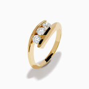 The D'Oro 14K Yellow Gold Diamond Bypass Ring features three round white diamonds in a row and a modern, open, curved band design, shown on a white background.