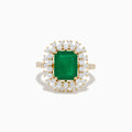 The 14K Yellow Gold Emerald and Diamond Halo Cocktail Ring showcases a large rectangular green emerald at the center, surrounded by a sparkling double halo of round white diamonds.