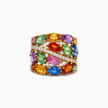 Introducing the 14K Yellow Gold Multi Sapphire and Diamond Statement Ring: This bold ring showcases a wide band of 14K yellow gold, highlighted by luminous oval sapphires in green, orange, pink, blue, and purple. A diagonal row of sparkling white diamonds crosses the center, creating a dazzling focal point that makes this sapphire ring an eye-catching and colorful addition to any jewelry collection.