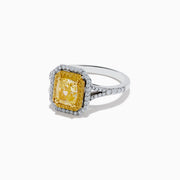 The Canare` 18K Two Tone Gold Yellow and White Diamond Ring features a radiant-cut yellow diamond center, framed by a double halo of white and yellow diamonds on a two-tone gold band.