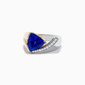 The Nahla Siri 14K Two-Tone Gold Tanzanite and Diamond Ring showcases a striking triangular blue tanzanite accented by a curved row of sparkling white diamonds on one side.