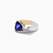 The Nahla Siri 14K Two-Tone Gold Tanzanite and Diamond Ring showcases a striking triangular blue tanzanite accented by a curved row of sparkling white diamonds on one side.