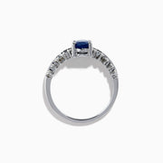 The 14K White Gold Blue Sapphire and Diamond Ring showcases an oval blue sapphire center, accented by two rows of round diamonds on each side, elegantly set against a white background.