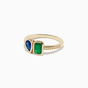 The 14K Yellow Gold Emerald and Sapphire Toi Et Moi Diamond Ring features a teardrop sapphire, rectangular green emerald, and small diamonds set along half the band, shown on a white background.
