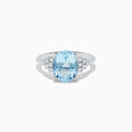 The Aquarius 14K White Gold Aquamarine and Diamond Ring showcases a large oval aquamarine center stone, accented by three rows of round diamonds on each side against a white gold setting.