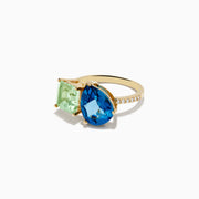 The 14K Yellow Gold Diamond Green Amethyst London Blue Topaz Toi Et Moi Ring showcases a square-cut Green Amethyst and a pear-shaped London Blue Topaz side by side, accented with sparkling Diamonds along the band.