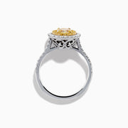 The 18K Two Tone Gold White and GIA Certified Yellow Diamond Double Halo Ring features a central oval yellow diamond, surrounded by white diamonds and additional diamonds set along the band.