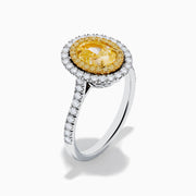 The 18K Two Tone Gold White and GIA Certified Yellow Diamond Double Halo Ring features a central oval yellow diamond, surrounded by white diamonds and additional diamonds set along the band.