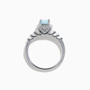 The Lab Grown Blue and White Diamond Halo Ring in 14K White Gold showcases a rectangular light blue center stone, surrounded by lab grown diamonds and accented with diamonds along the band for added sparkle.