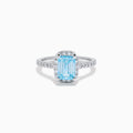 The Lab Grown Blue and White Diamond Halo Ring in 14K White Gold features an emerald-cut blue center stone with lab grown diamond accents, beautifully showcased on a white background.